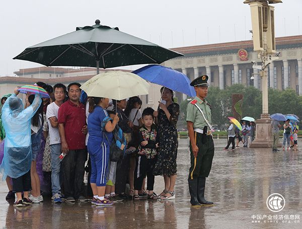 天安門(mén)廣場(chǎng)一執勤武警將崗傘讓給群眾避雨，自己冒雨站崗